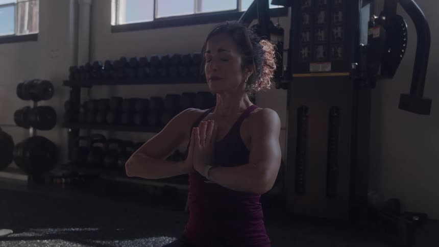 The woman is meditating in the gym