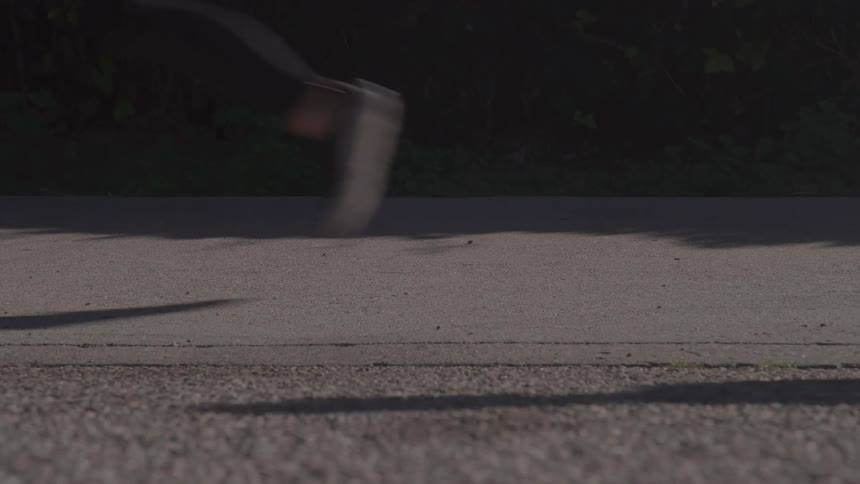 Group of people jogs on the side of a paved road during the daytime