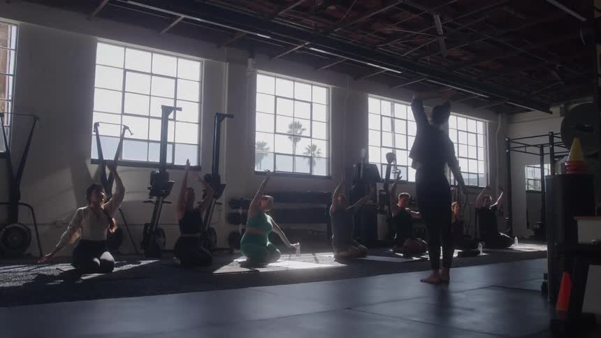 Woman in a gym giving yoga class