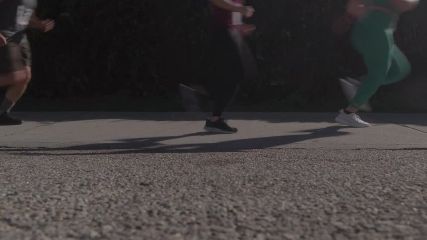 People jog along a paved road in a daylight