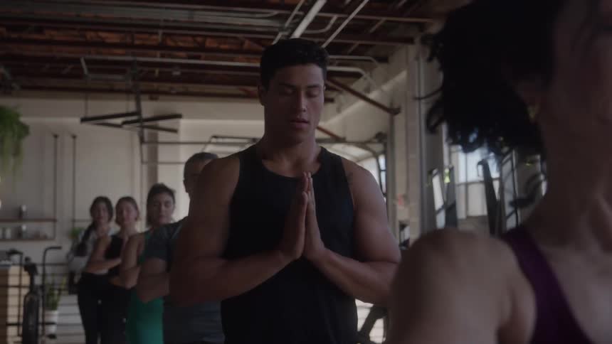 A group of people practice yoga together in a gym