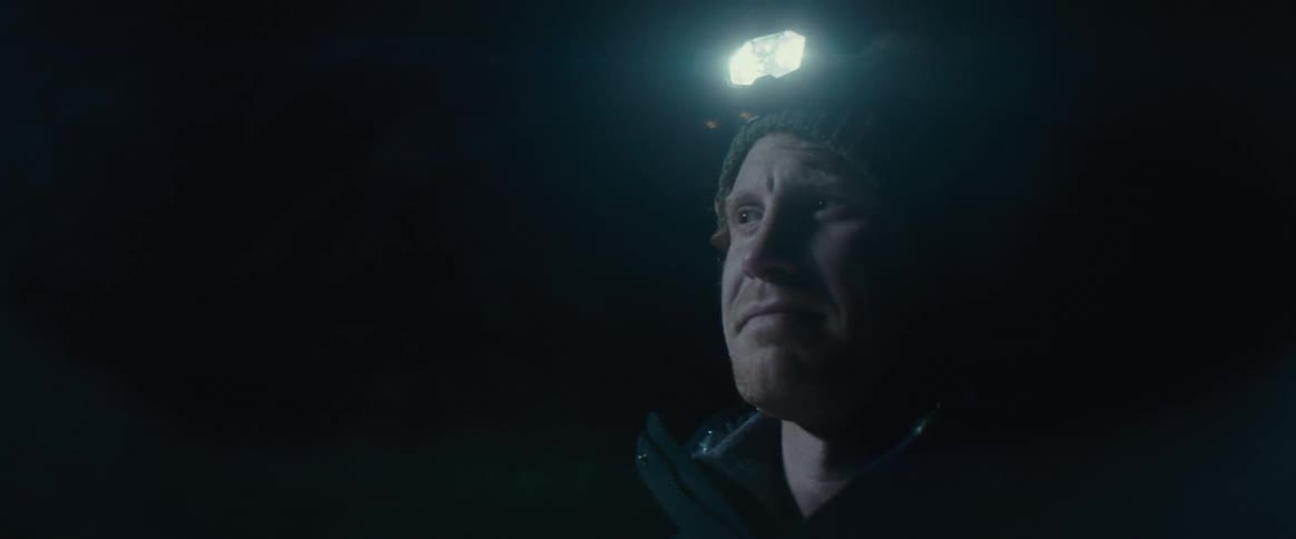 Man outdoors at night with a flashlight on his head