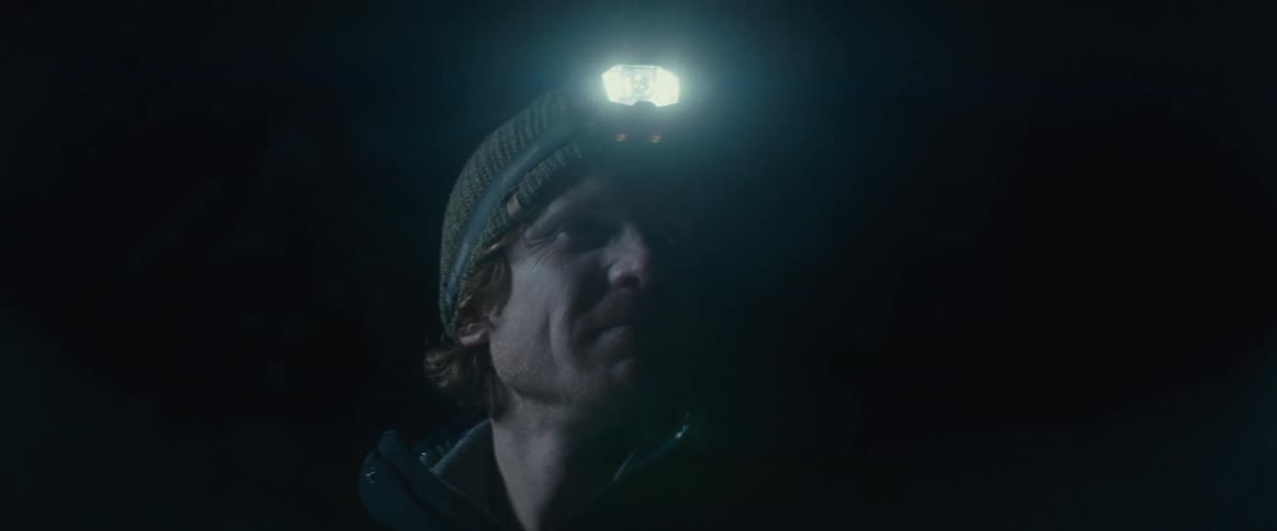 Man with a flashlight on his head while standing outdoors at night