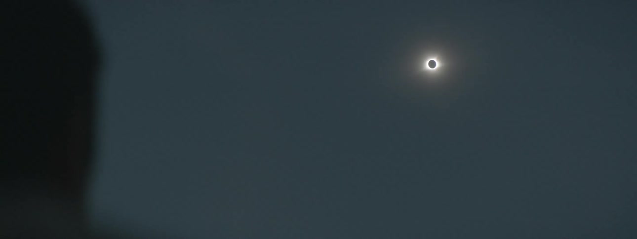 A blurry view of someone and a partial view of a solar eclipse