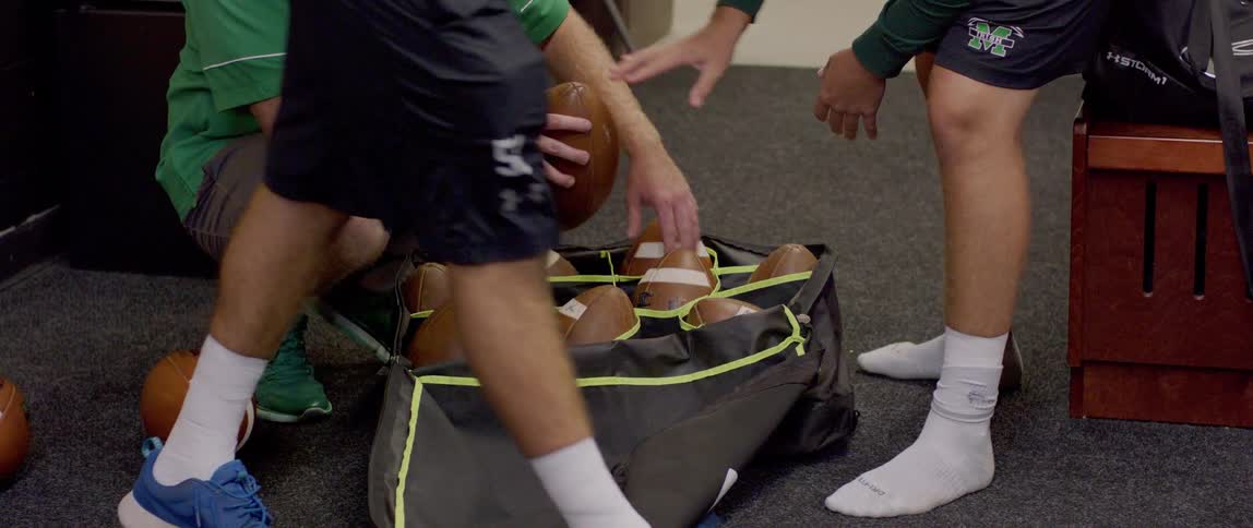 Footballs are being handed out in the locker room