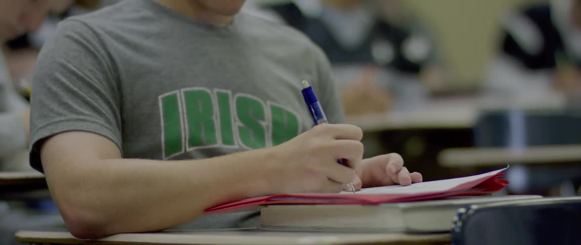 Student writing in a notebook in the classroom