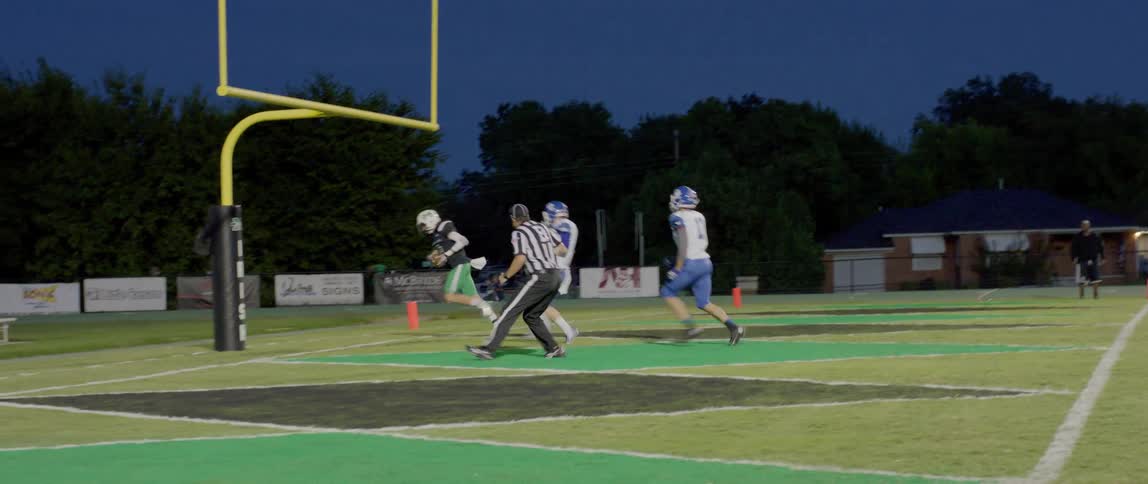 The football player catches the ball and scores a touch down