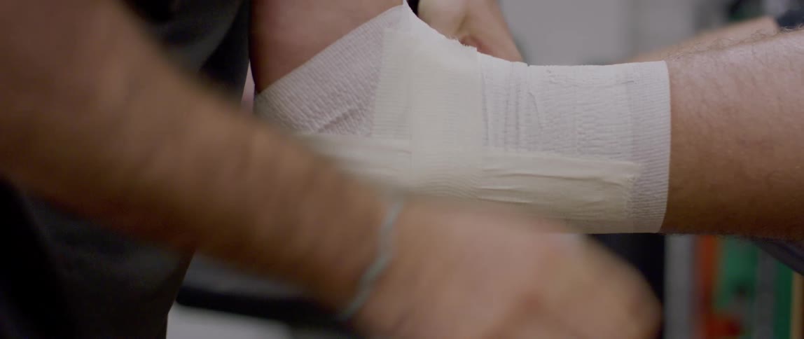 Hands bandage a persons ankle