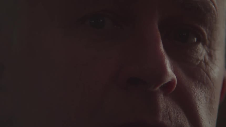 A closeup of a middleaged mans face with a focus on his eyes and nose is shown the lighting is dramatic with half of his face in shadow and the other half illuminated