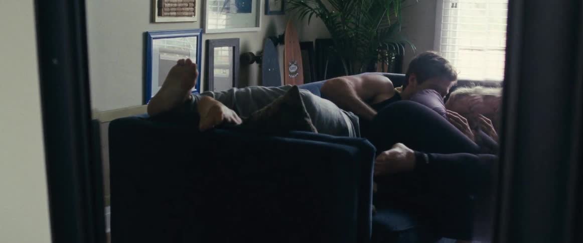 A couple of people laying on the couch playing around