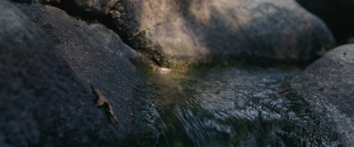 A close up view of some water flowing through some rocks