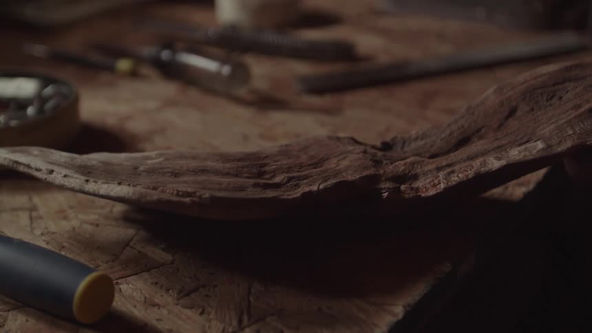 A person chisels wood