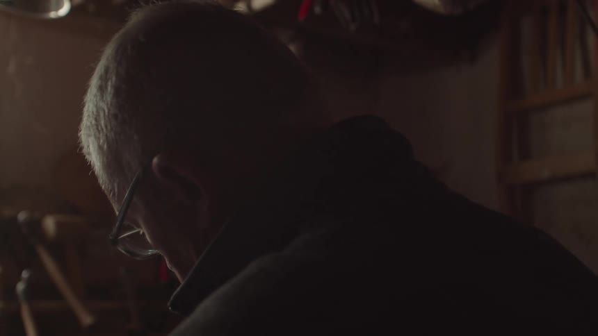 Elderly man working inside his garage