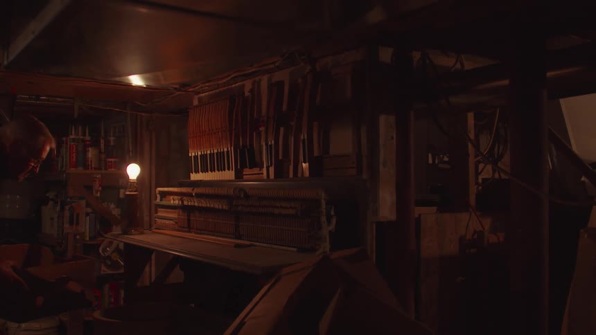 Dimly lit workshop with a light bulb on and tools hanging on the wall