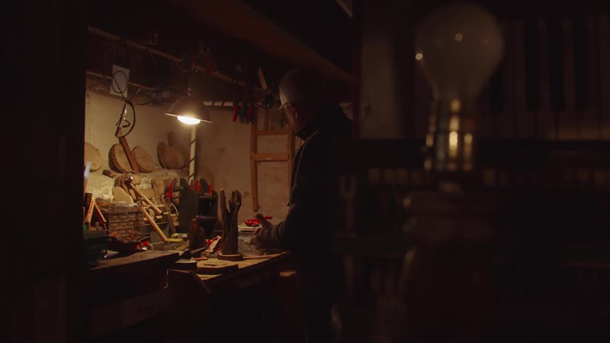 Man working at a cluttered workshop bench