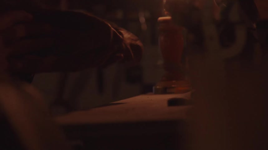 Male hands placing a rough wood piece on top of a wooden table indoors