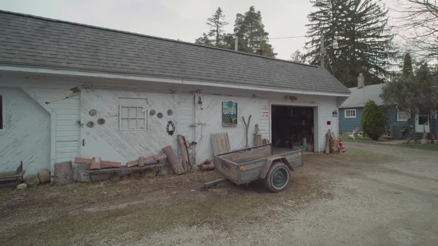 White garage with an open door and a trailer parked in front