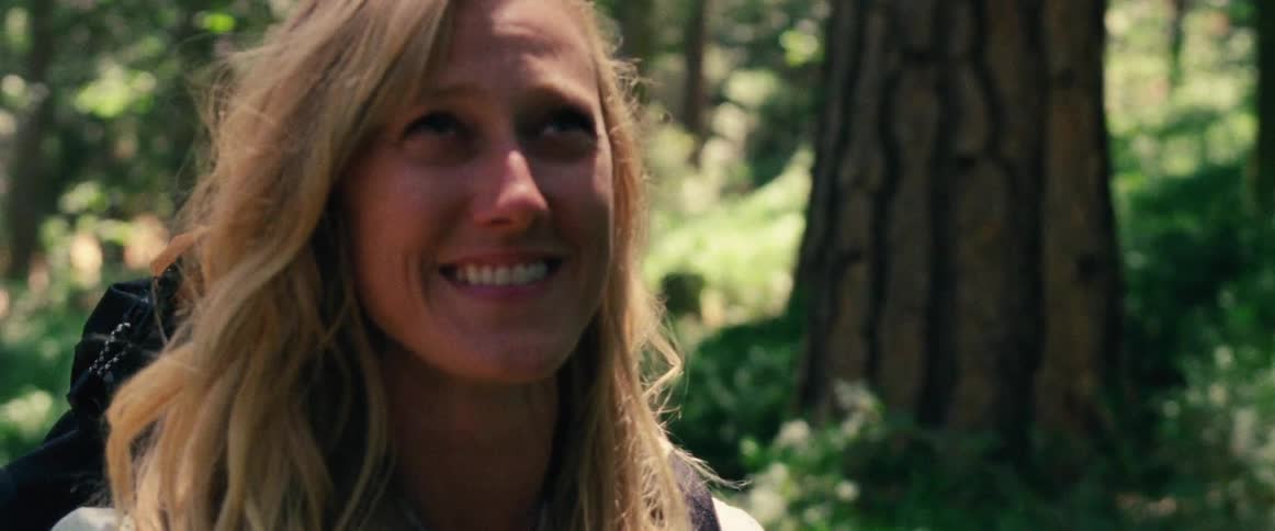 A woman smiling and looking up at something outside