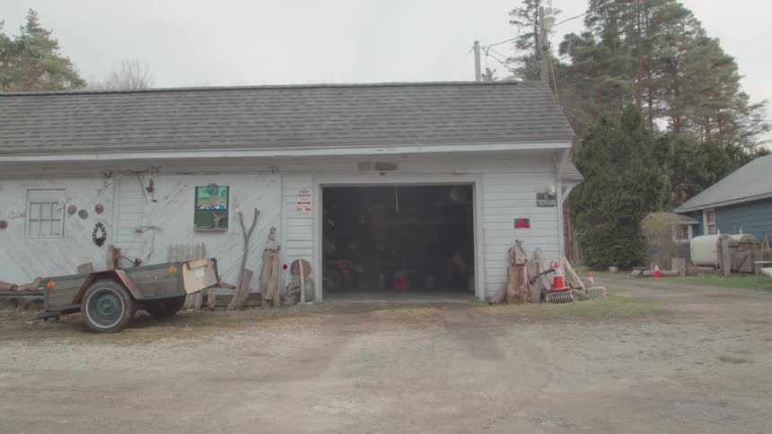 The man drives the tractor into the garage