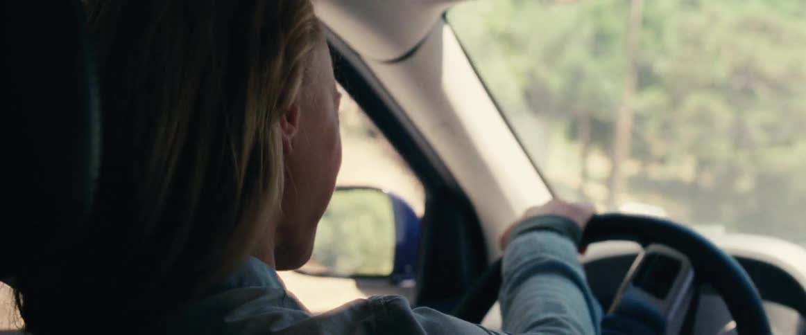 A woman driving a car and smiling