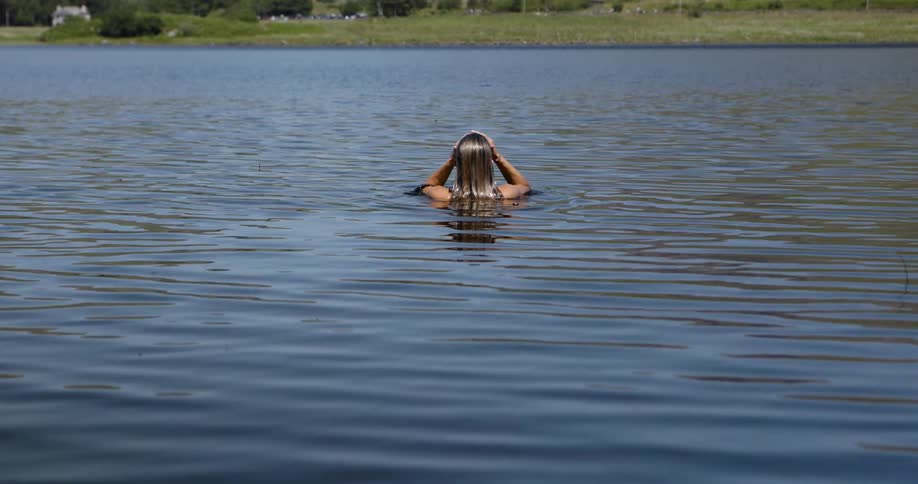 The woman stands in the lake water