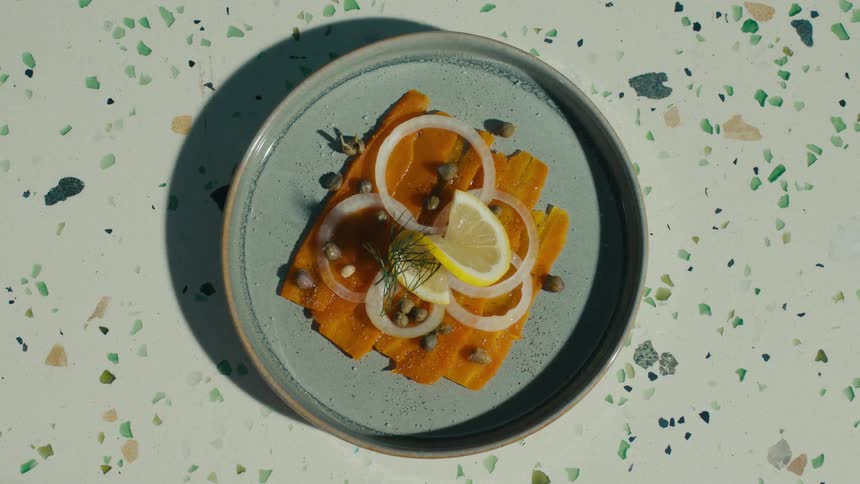 Close up of a plate of food placed on a surface by a woman