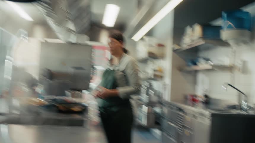 A young female chef preparing a meal in a kitchen during daytime