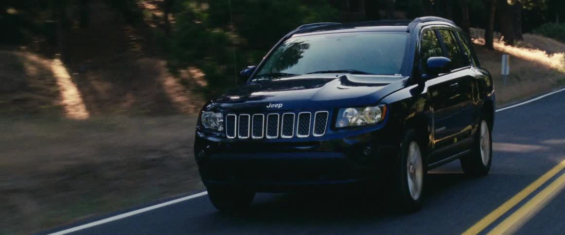 Black jeep driving down a country road