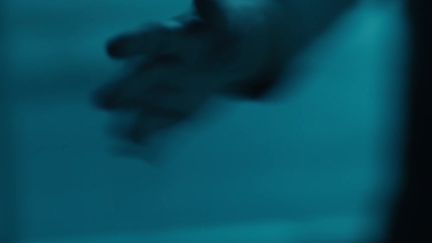 Person indoors performing a series of hand movements