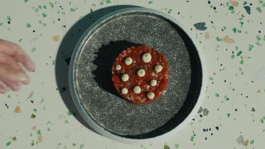 Plate with beef tartare decorated with white sauce dots