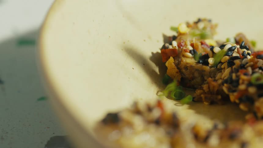 Plate with pieces of food topped with sesame seeds and colorful seasonings