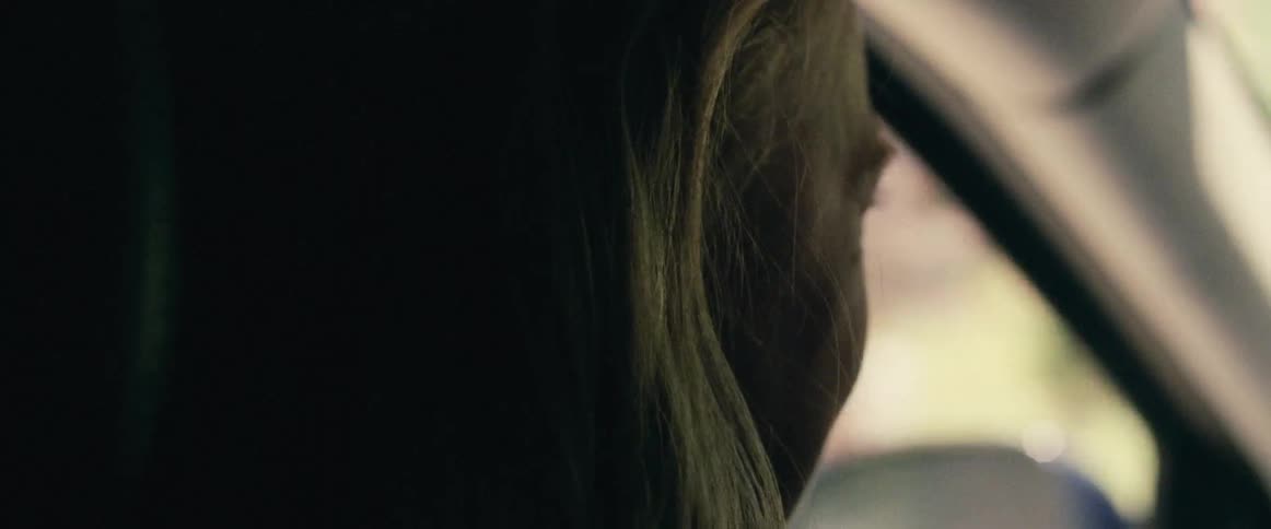A close up view of a person's head as they are driving a car