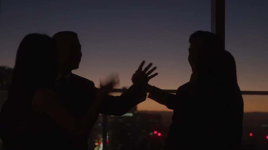 Friends high five in the dark in the building