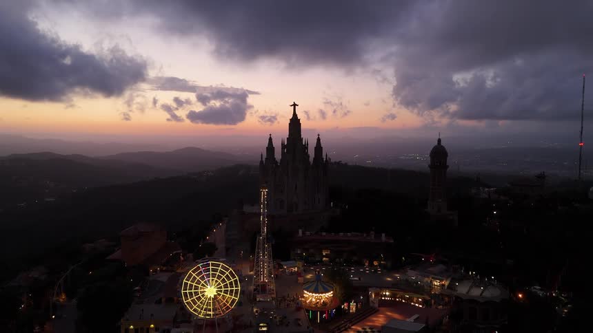Theme park stands on a hill overlooking a foggy valley under a red tinted sky