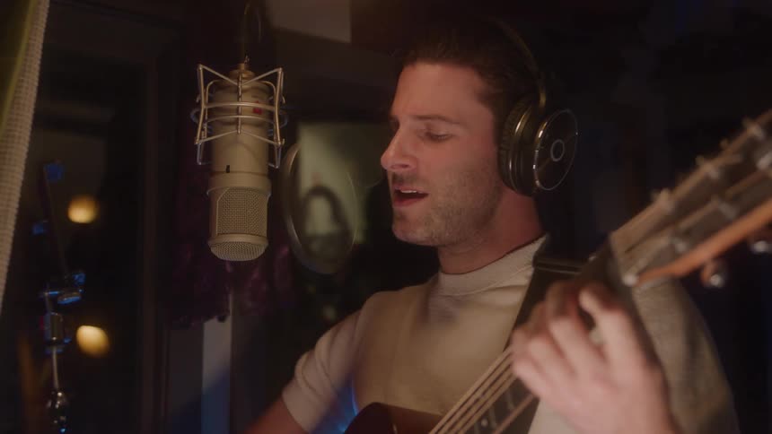 The man is singing into the microphone