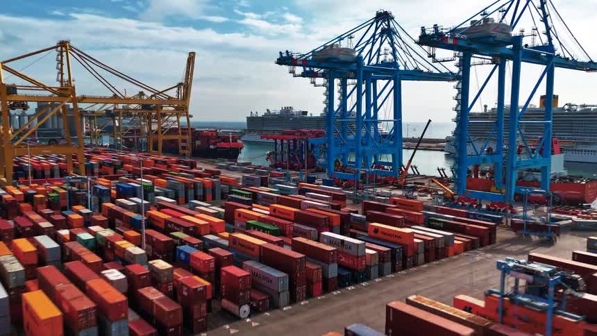 Stacked containers at a port with cargo cranes