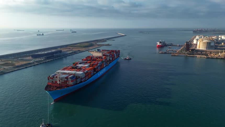 Ship with containers sailing near a port