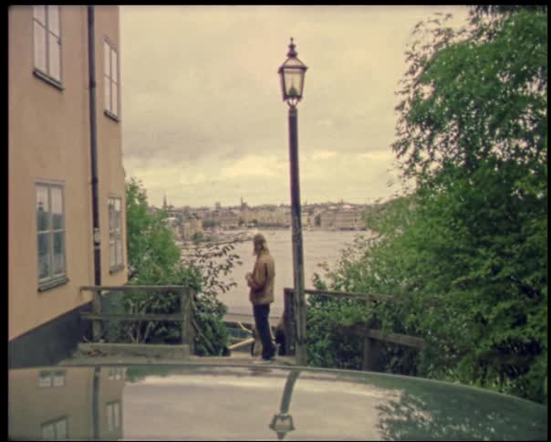 Man standing near a lamp post overlooking the river view