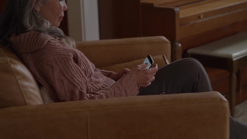 Woman sitting on a couch using a cellphone