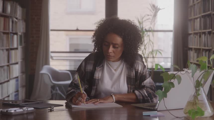 Woman focused on typing on a laptop at a wooden table