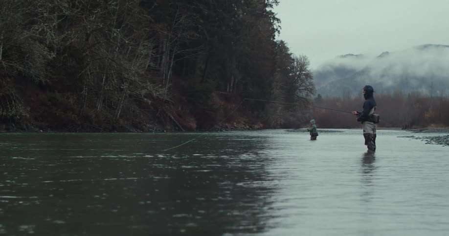 Fishermen practicing fishing in a river surrounded by trees