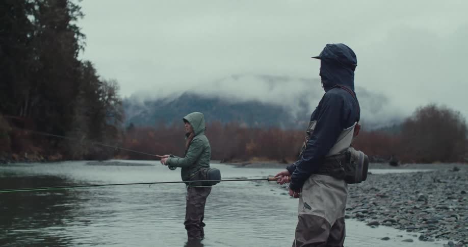 Two anglers standing in the river with fishing rods