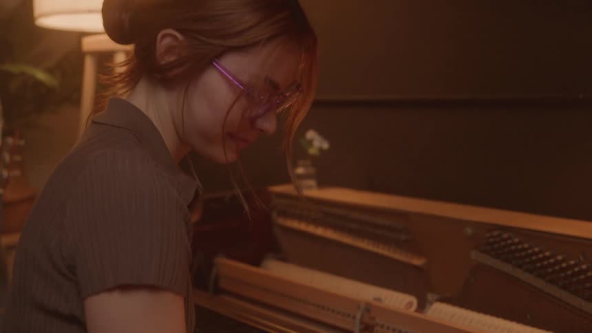Woman at a piano making notes in a book