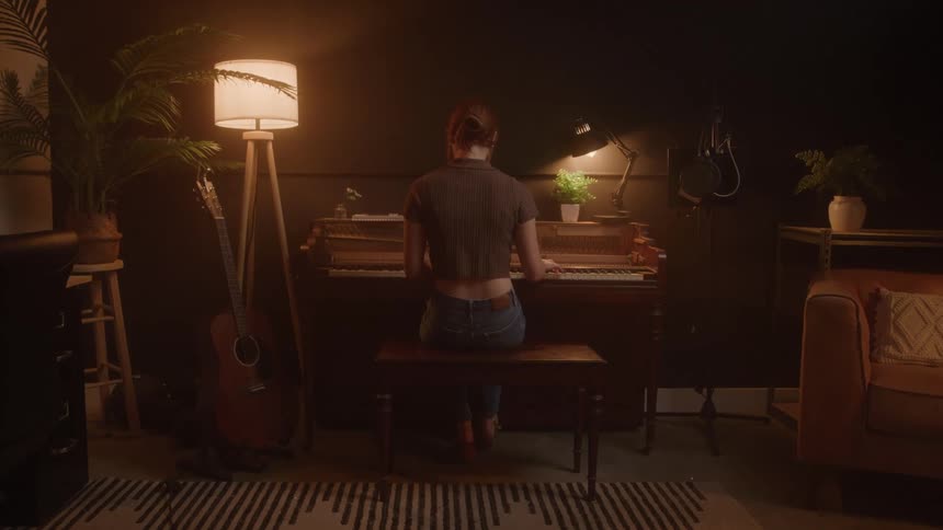 The woman plays the piano in the living room