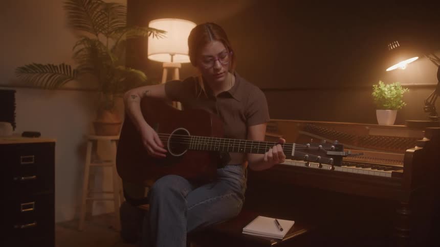 Woman sitting playing guitar
