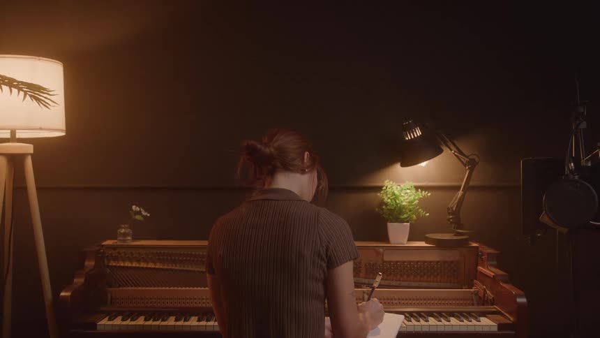 A person sits on a piano bench looks down at a music sheet and writes with a pen