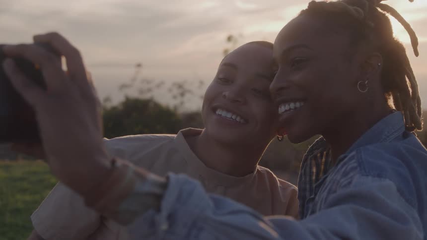 Two smiling women outdoors and taking a selfie