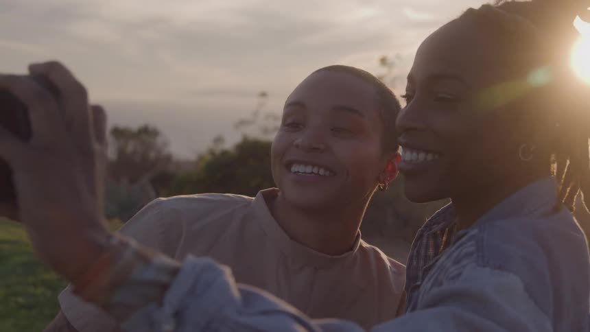 Two smiling women in nature taking a selfie