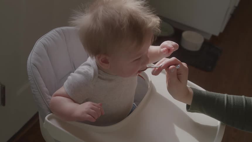 Person feeding a baby with a spoon