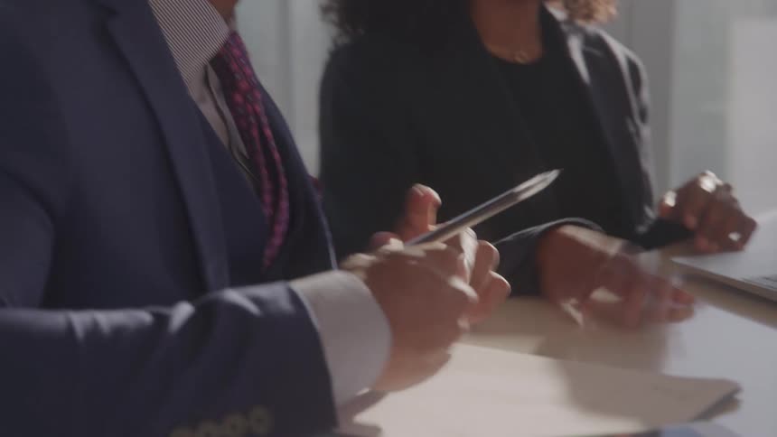 Two coworkers talk at a desk